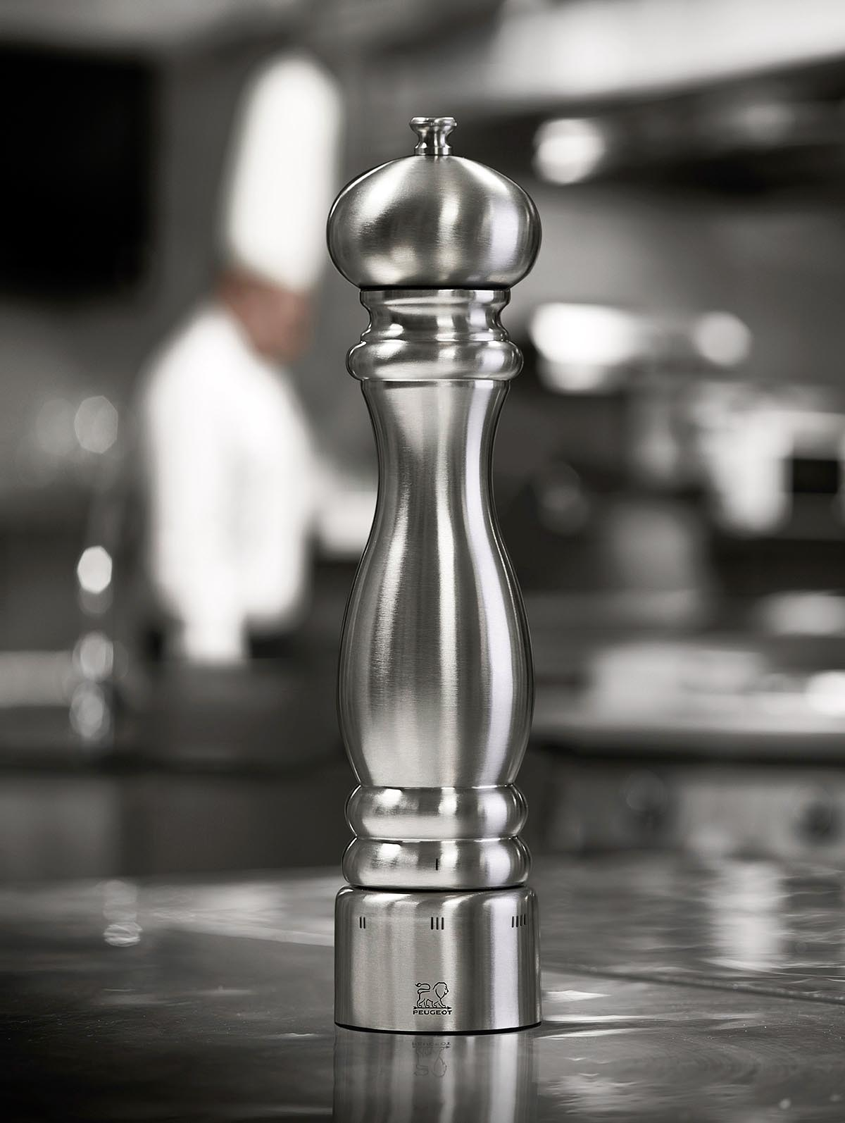 Elegancki młynek Peugeot inox 22 cm na tle kuchni Stalowy młynek do przypraw Peugeot w kuchni, 22 cm, mechanizm U-Select