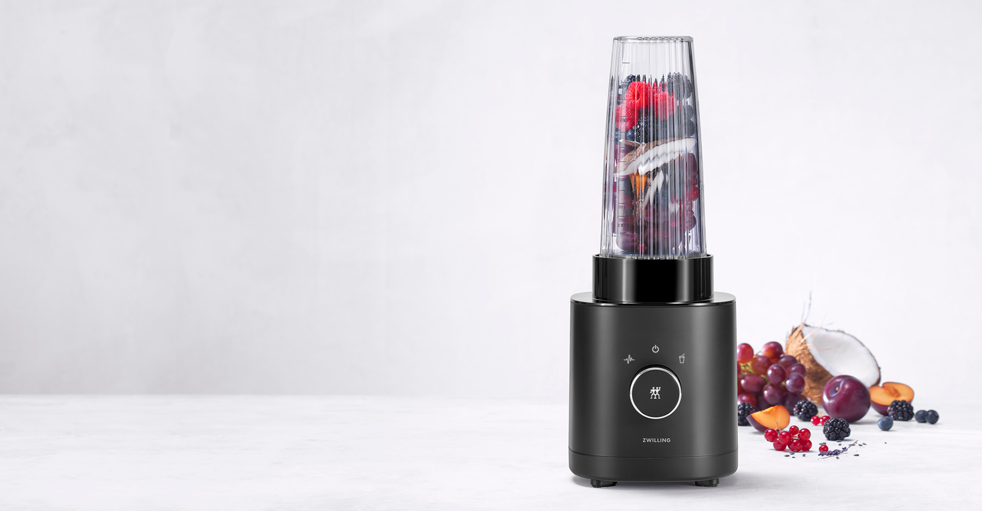 Czarny blender Zwilling z owocami w tle, luksusowy design i automatyczne funkcje.