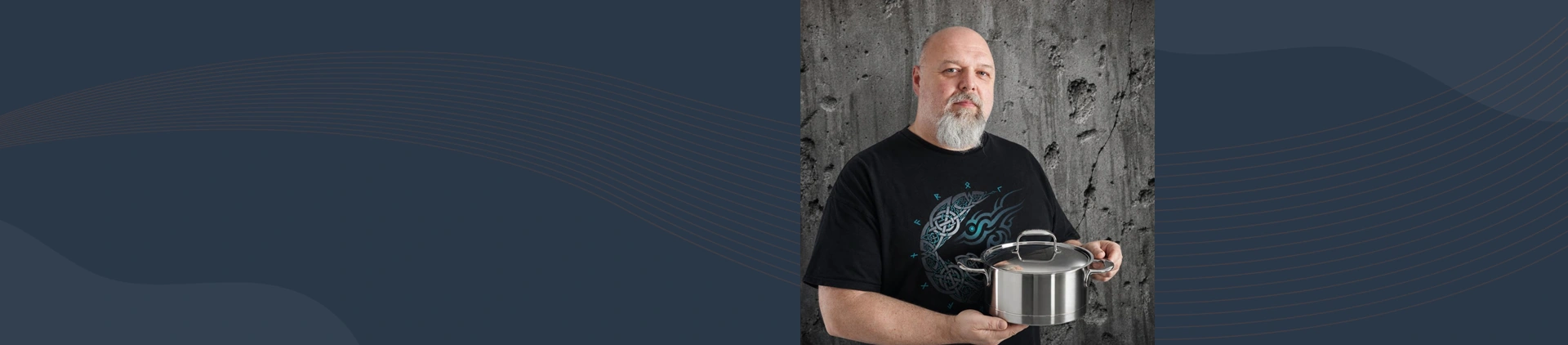 Mężczyzna prezentuje garnek ze stali szlachetnej Demeyere Atlantis 4L na tle betonowej ściany