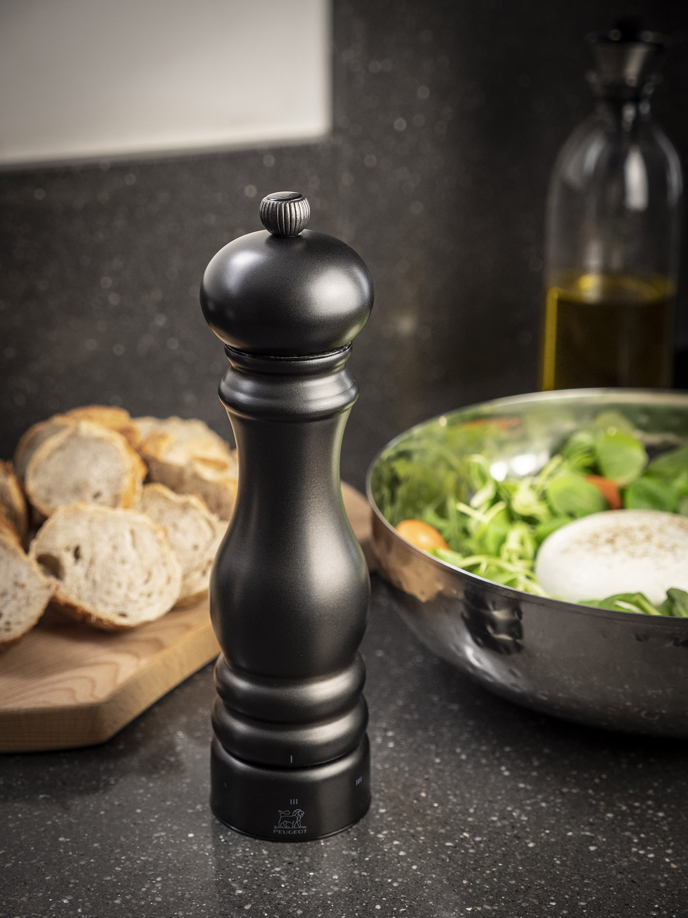 Elegancki młynek Paris Chef Peugeot z mechanizmem U-Select, 22 cm. Stalowy młynek do przypraw Peugeot w kolorze carbon na kuchennym blacie.