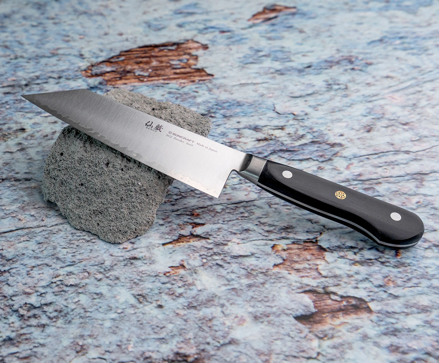 Japoński nóż Bunka Suncraft SG2 na tle kamienia i tekstury