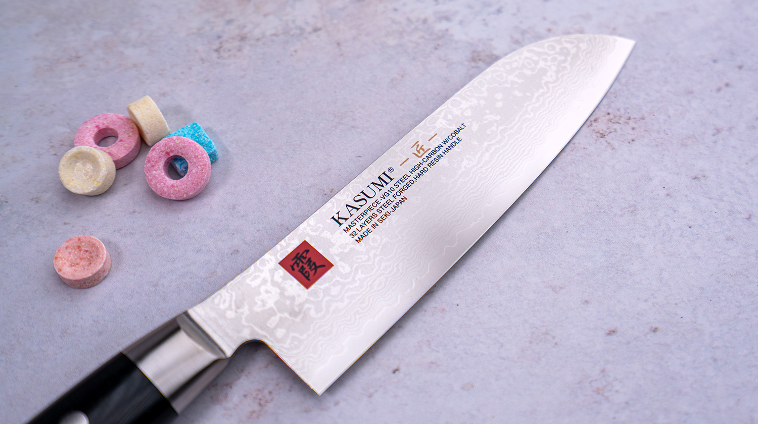 Japoński nóż Santoku Kasumi 18 cm z damasceńskiej stali VG-10 GOLD na marmurowym tle.