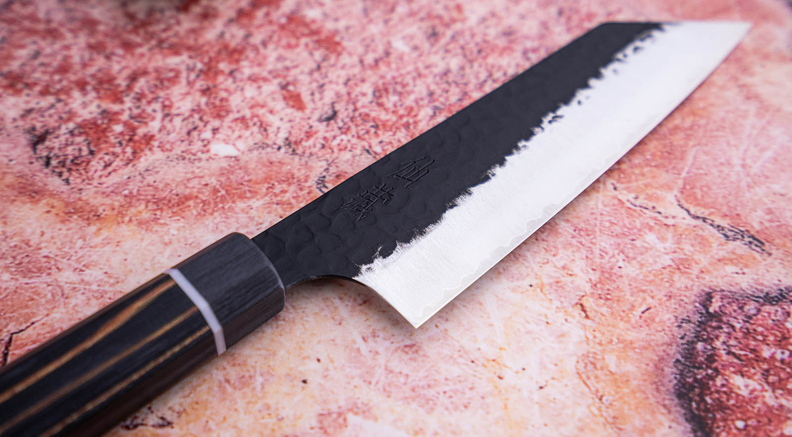Japoński nóż Bunka 16,5 cm z stali SPG STRIX na tle marmurowej deski.