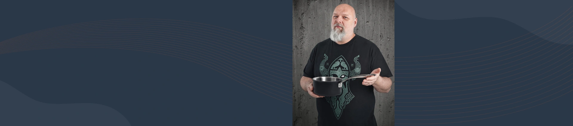Mężczyzna prezentuje stalowo-ceramiczny rondel Demeyere Black 5 o pojemności 1,5 litra na tle betonu