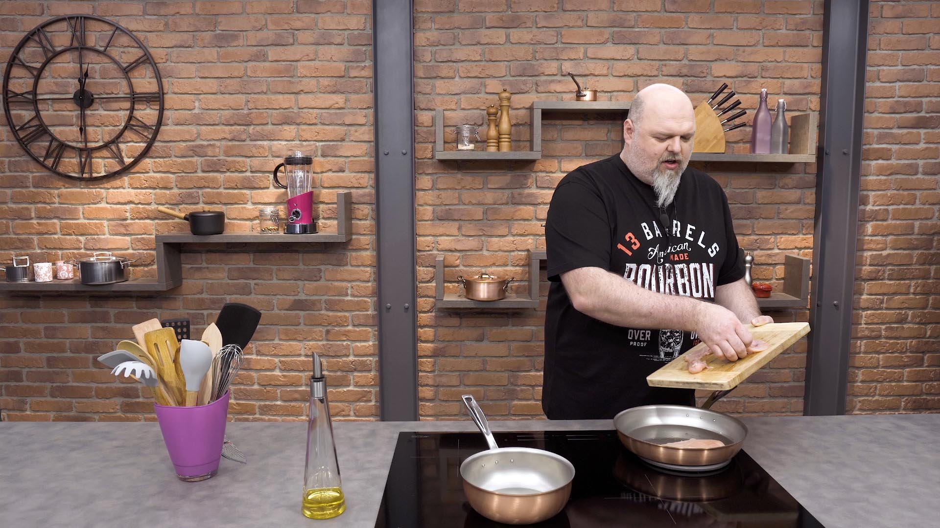 Miedziany wok Falk na kuchennym blacie, obok garnków i przyborów.