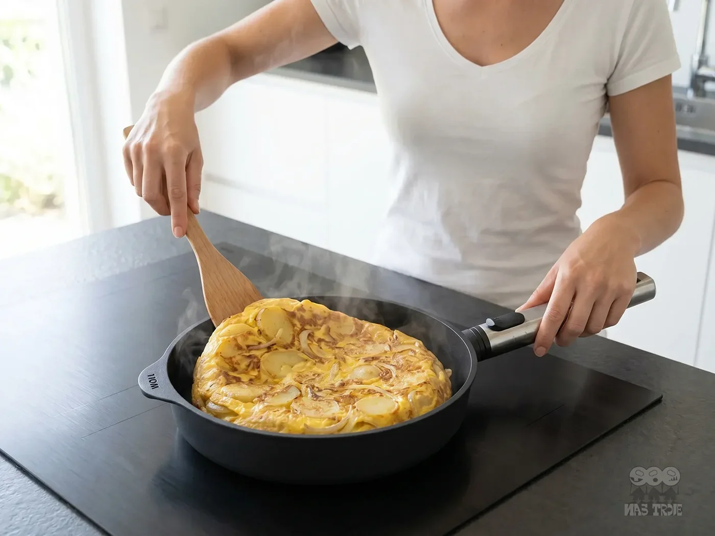 Przygotowywanie omletu na tytanowej patelni Eco Logic QXR PRO z nieprzywierającą powłoką. Kobieta gotująca omlet na patelni tytanowej Eco Logic QXR PRO z odpinanym uchwytem.