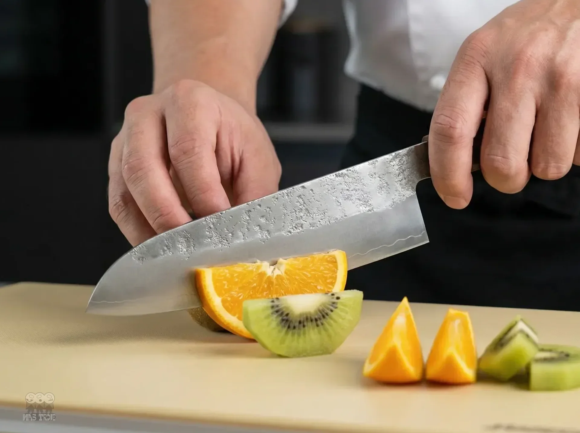 Japoński nóż Santoku krojący owoce na desce do krojenia w eleganckiej kuchni.