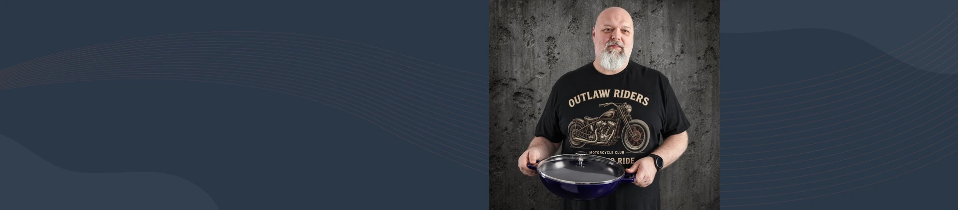 Mężczyzna prezentujący żeliwny wok Staub z pokrywką w kolorze ciemnoniebieskim, pojemność 4,4 l