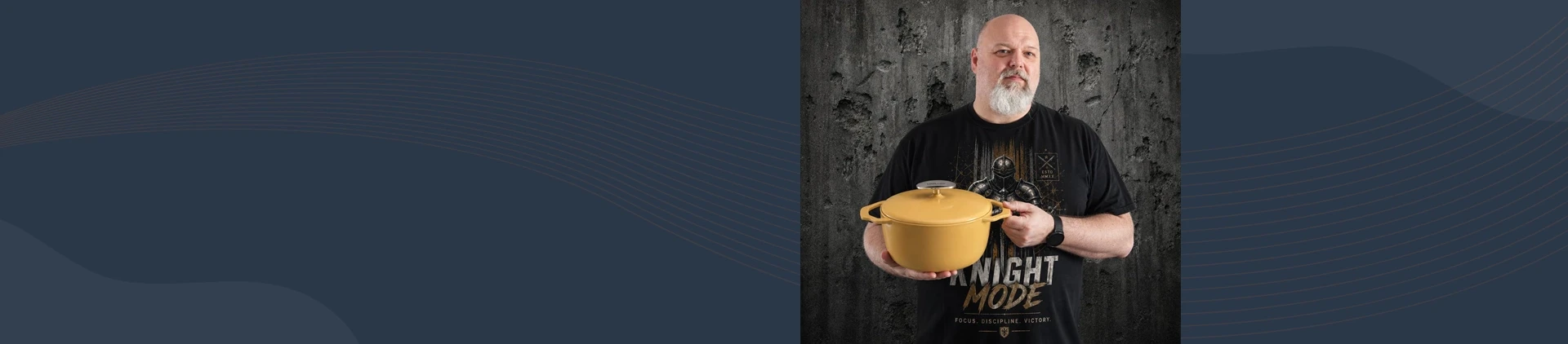 Mężczyzna prezentuje żółty, żeliwny garnek Unilloy 3,8 l na tle betonowej ściany
