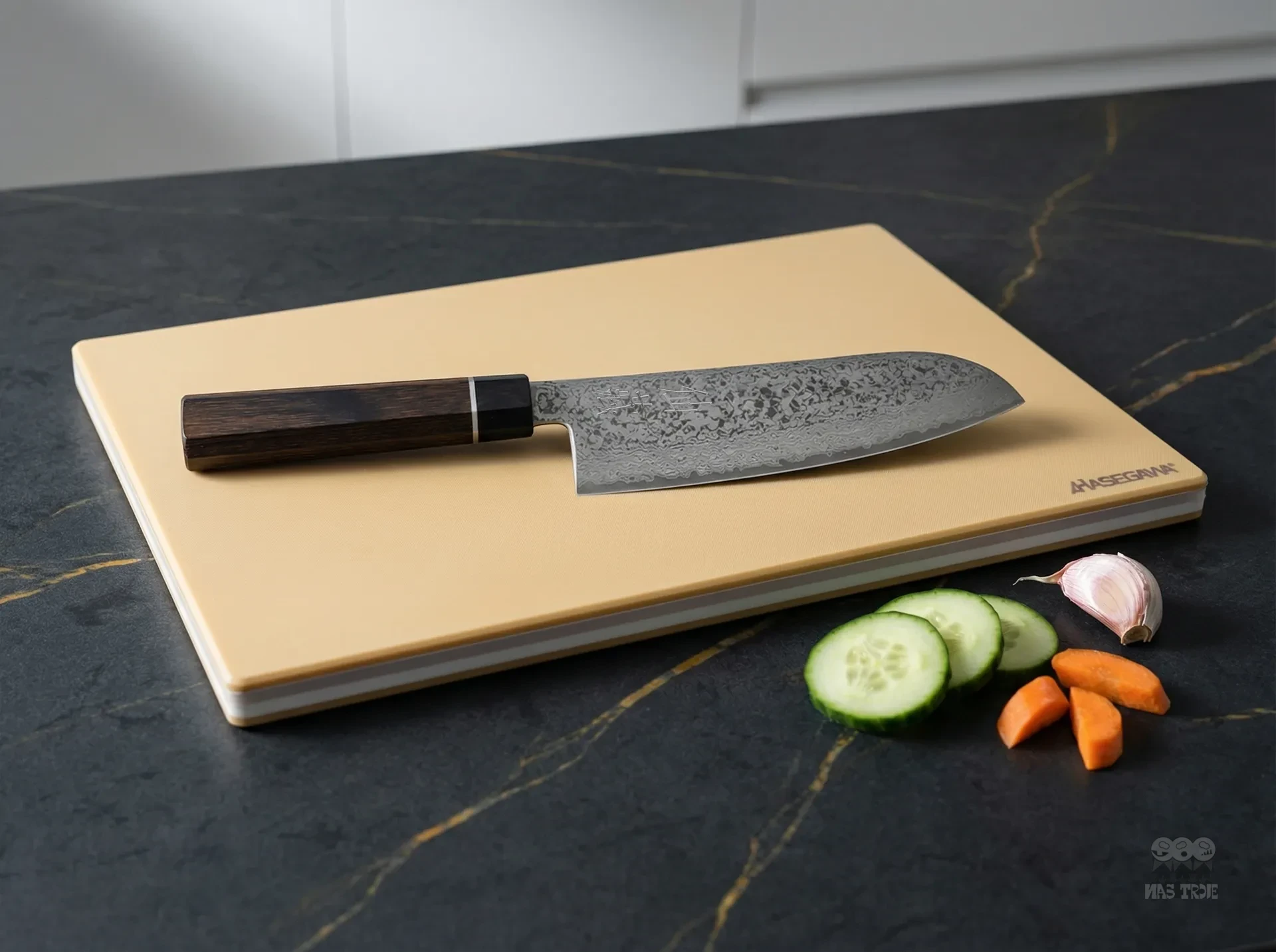 Japoński nóż Santoku Senzo Black na desce Hasegawa, obok plasterki ogórka, marchewki i ząbek czosnku
