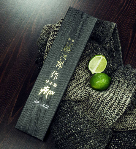 Nóż kuchenny Tojiro Shippu Black, 24 cm, na tle dzianiny i limonki
