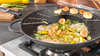 Żeliwny wok Staub Graphite Grey z warzywami i owocami morza na kuchence