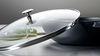 Żeliwny wok Staub Graphite Grey z pokrywką, na blacie kuchennym.