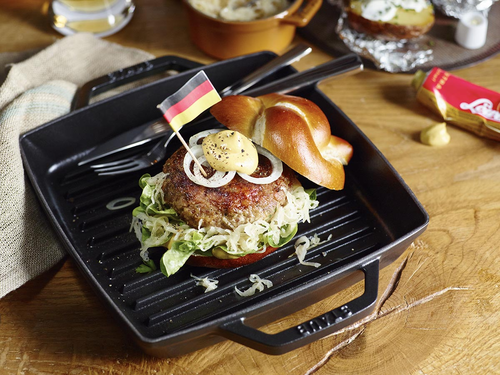 Żeliwna patelnia grillowa Staub Black z burgerem i dodatkami
