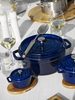 Staub Dark Blue garnek żeliwny, 5,2 l z nieprzywierającą glazurą na eleganckim stole.