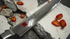 Japoński nóż Kasumi Damascus 16-warstwowy do sushi na tle betonu.