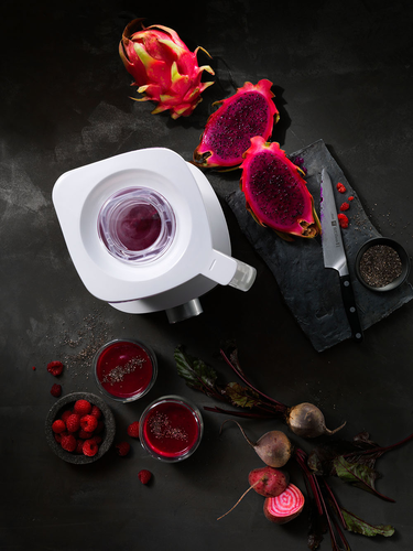 Luksusowy blender Zwilling Enfinigy srebrny na ciemnym tle z owocami i napojami.