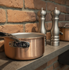 Miedziany rondel Falk Signature na tle ceglanej ściany, pojemność 2,7 litra