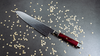 Ultimate Aranami Mcusta Zanmai - Mistrzowski nóż Santoku, 18 cm, na tle drobnych dekoracji.