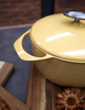 Żółty garnek Unilloy z serii Yellow, 3 litry, lekki i nieprzywierający, na drewnianej desce.