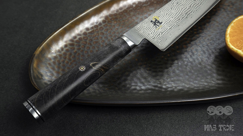 Damasceński nóż Santoku 5000 MCD BLACK 67 Miyabi na ceramicznym talerzu
