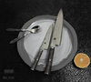 Luksusowy nóż Miyabi Gyuto 5000 MCD BLACK 67 na eleganckim talerzu z owocem.
