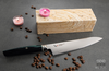 Mcusta Zanmai Revolution Kiritsuke, nóż japoński SPG2, 23 cm, na tle drewnianej deski i kawowych ziaren.