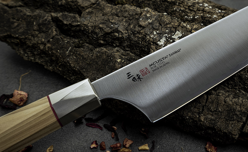 Mcusta Zanmai Beyond Santoku, stal Aogami Super, na tle drewna