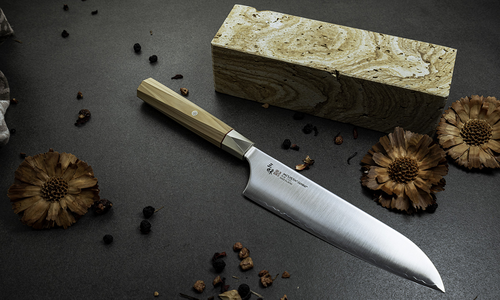 Mcusta Zanmai Gyuto Beyond - japoński nóż kucharza, stal Aogami Super, 21 cm na tle kuchennym.