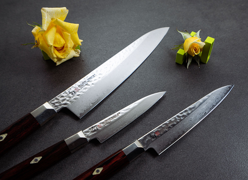 Nóż Mcusta Zanmai Supreme Hammered Sujihiki, damasceński 24 cm na tle kwiatów