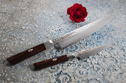 Mcusta Zanmai Shotoh, 15 cm, piękny nóż damasceński Supreme Hammered na tle kwiatowym.