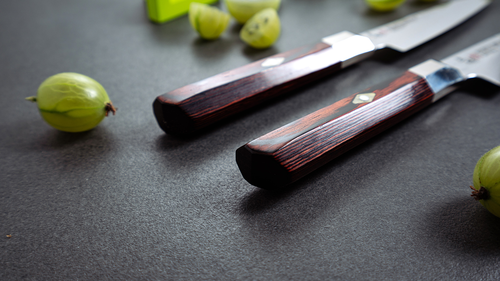 Nóż Santoku Mcusta Zanmai Supreme Hammered obok agrestu na blacie