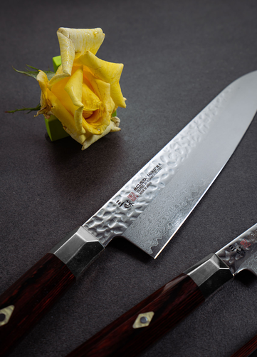 Nóż kucharza Mcusta Zanmai Gyuto, seria Supreme Hammered, 21 cm, VG-10, obok żółtej róży.