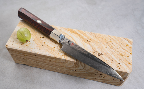 Nóż Gyuto Mcusta Zanmai Supreme Hammered, 24 cm, na kamieniu.