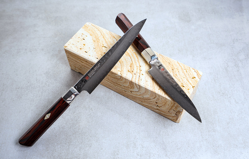 Mcusta Zanmai Supreme Hammered nóż do obierania, damasceński, 9 cm, na tle kamiennego bloku.
