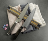 Magnetyczna listwa Bisbell z japońskim nożem na tle tkanin