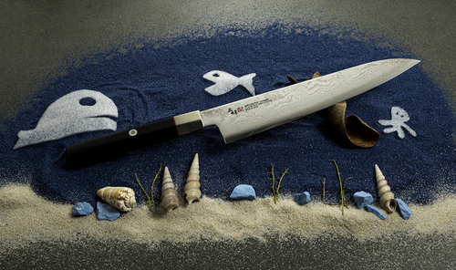 Mcusta Zanmai Splash Damascus nóż Gyuto 18 cm na tle morskiej aranżacji