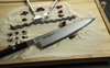 Japoński nóż kucharza Gyuto Mcusta Zanmai Splash Damascus na tle piasku