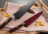 Nóż Santoku Mcusta Zanmai Supreme Ripple na tle drewnianej deski