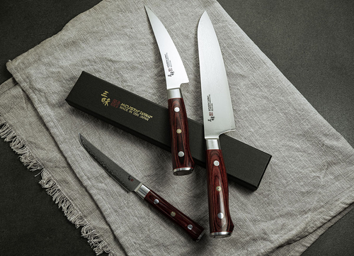 Mcusta Zanmai Classic Pro Flame nóż do warzyw 9 cm na lnianym tle.