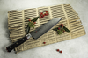Nóż Santoku Classic Pro Zebra Mcusta Zanmai na tekturowej podstawce z czerwonymi jagodami.