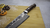 Mistrzowski nóż Santoku 18 cm Takeshi Saji VG-10 na drewnianej desce.