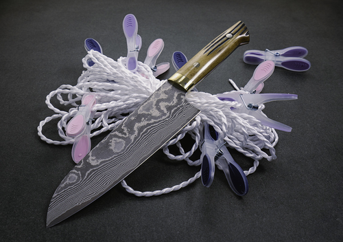 Takeshi Saji Santoku, 61-warstwowy nóż VG-10, otoczony klamerkami na sznurze.