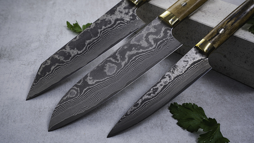 Japoński nóż kucharza Takeshi Saji YBB VG-10, 61-warstwowy, 18 cm, na tle betonu