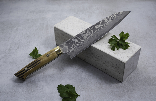 Nóż Gyuto Takeshi Saji VG-10 na tle ziół i kamienia