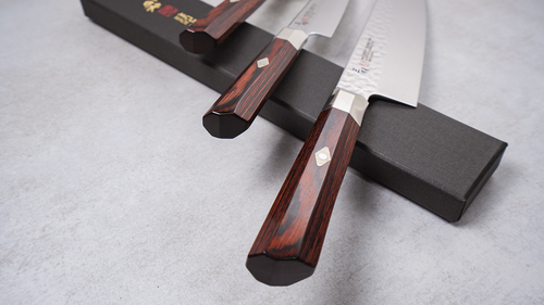 Damasceński nóż Nakiri Mcusta Zanmai Supreme Hammered na stole