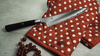 Japoński nóż Santoku Miyabi 4000 FC na czerwonej rękawicy