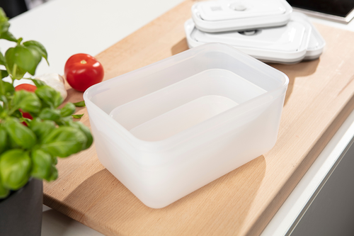 Zwilling Fresh & Save - pojemnik próżniowy na drewnianej desce z bazylią i pomidorami w tle.