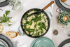 Staub Mint żeliwny garnek z risotto i warzywami na elegancko nakrytym stole.