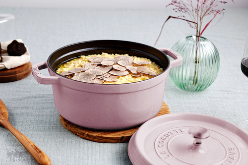 Żeliwny garnek Sakura Staub z nieprzywierającą powłoką, 2,2 l, różowy, na eleganckim stole.